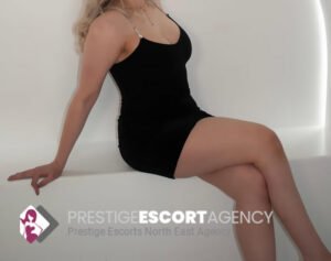 Woman in black dress sitting on a white bench.